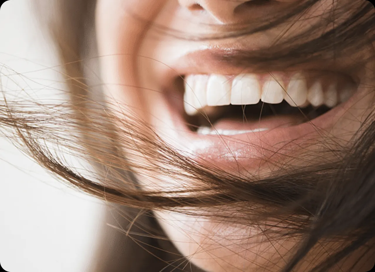 Femme souriante avec une belle dentition, résultat d'un traitement orthodontique